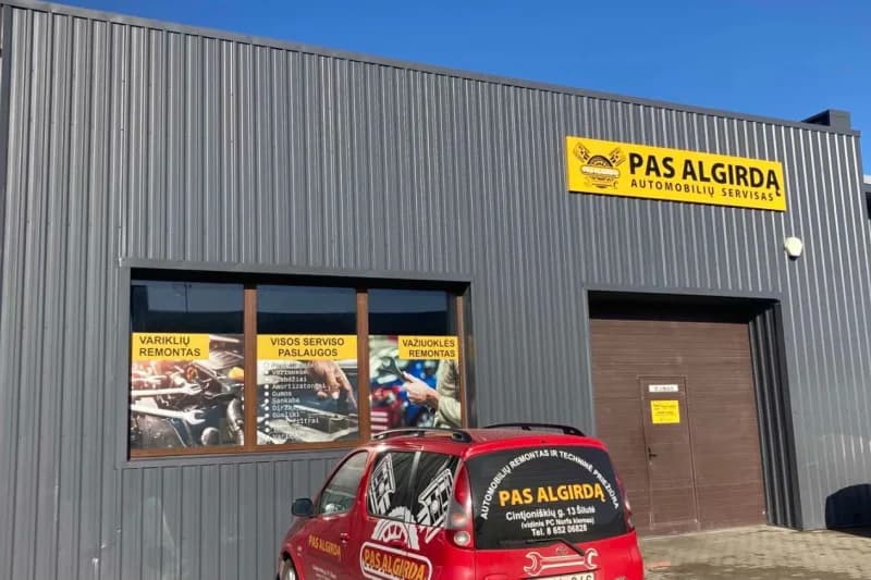 Automobilių serviso „Pas Algirdą“ pastatas Šilutėje su iškaba ir serviso automobiliu